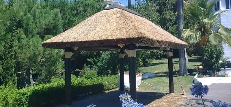 Pérgola de junco africano rodeada de setos