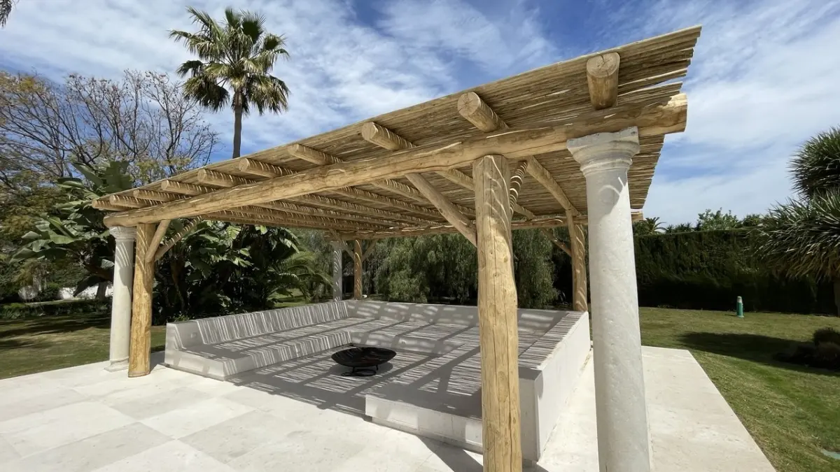 Pérgola de madera con columnas en un jardín de Marbella