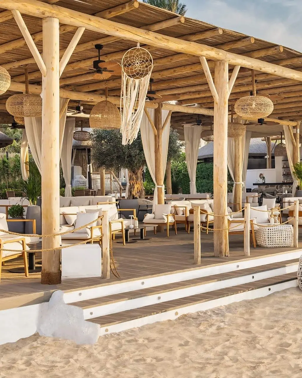Beach club with a eucalyptus post pergola and natural fibre lamps