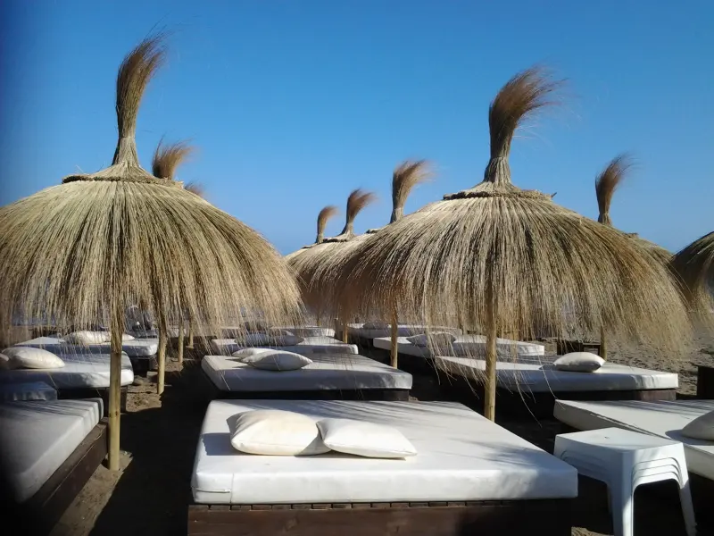 Ombrelloni in canna con letti da spiaggia a Estepona