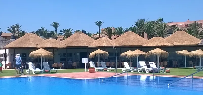 Thatched umbrellas beside a hotel pool in Sotogrande